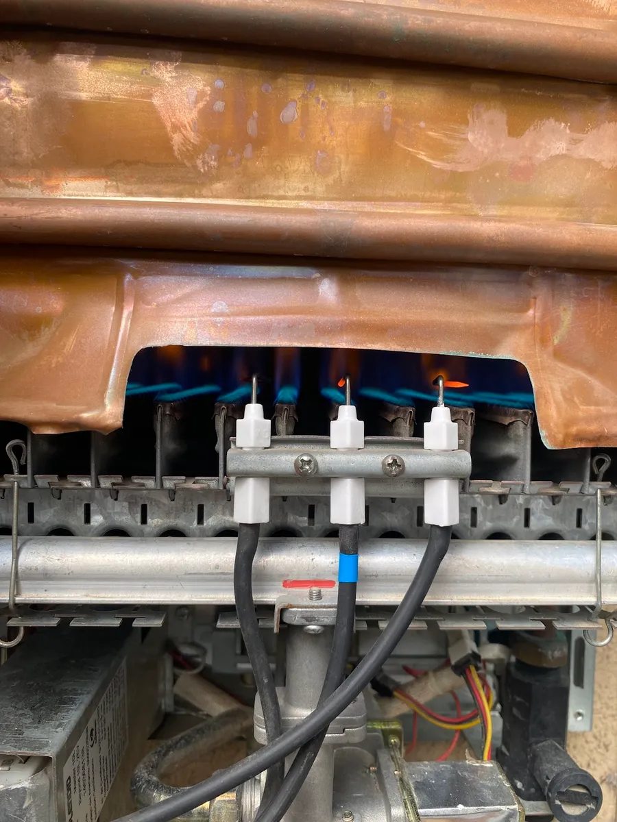 Interior de un calefont con los quemadores encendidos en llama azul — foto de la ficha de Google de Gasfiter en Talca