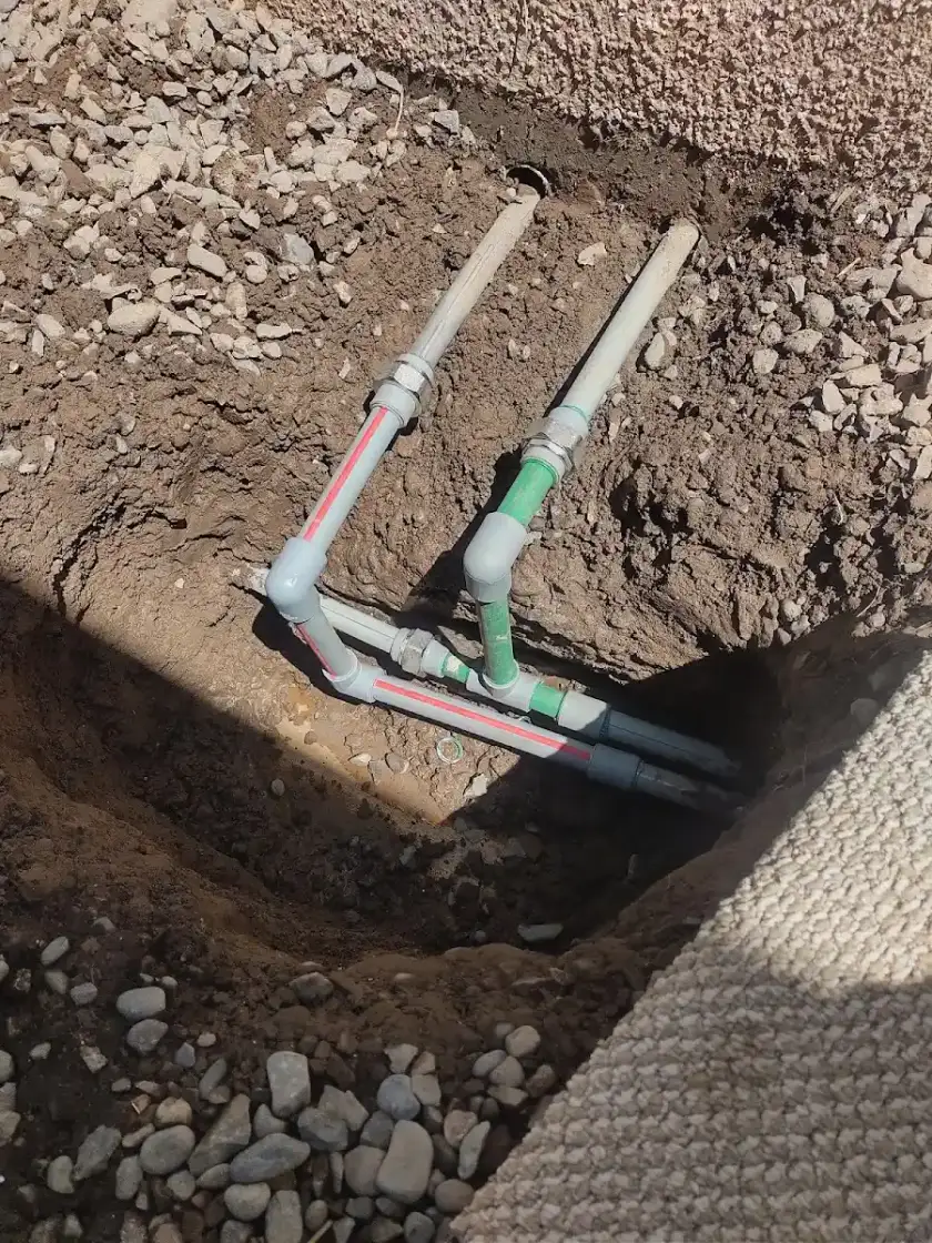 Cañerías de agua PPR recién instaladas en una zanja de obra