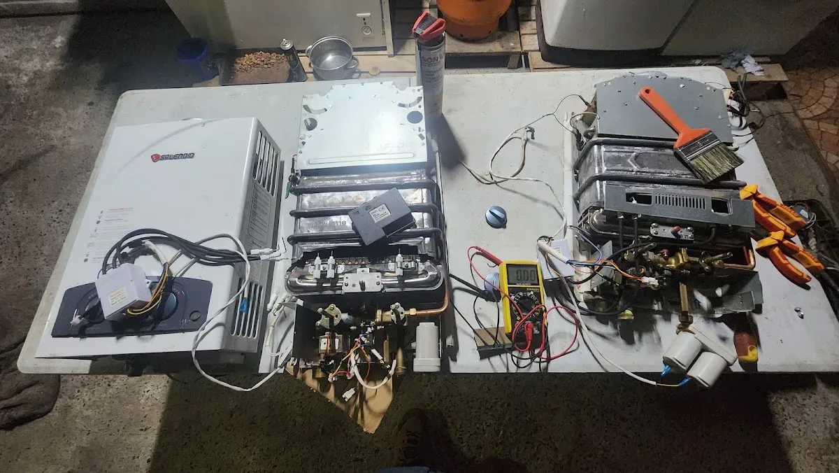 Mesa de trabajo con partes de calefont y multímetro durante una reparación