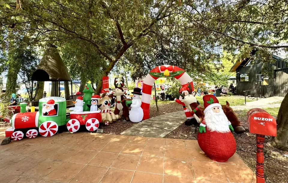 Patio del jardín decorado con un tren navideño e inflables