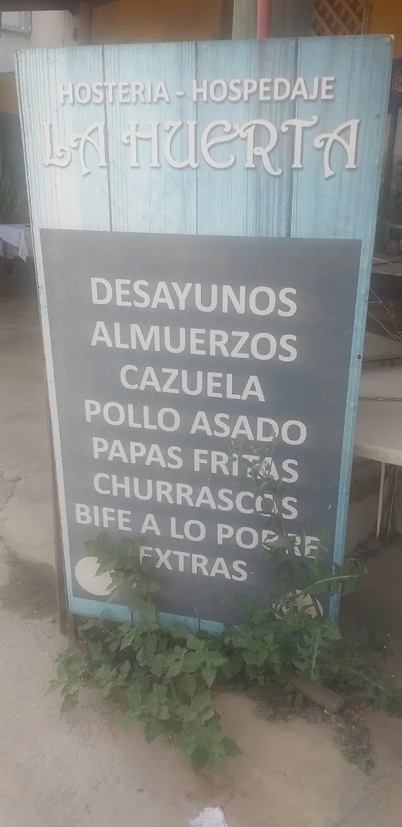 Letrero pintado a mano de Hostería La Huerta con su menú: desayunos, almuerzos, cazuela, pollo asado, papas fritas, churrascos y bife a lo pobre