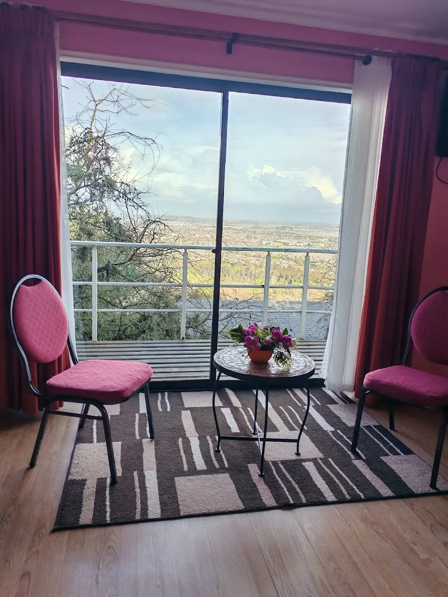 Interior de habitación con ventana y vista a la ciudad de Talca