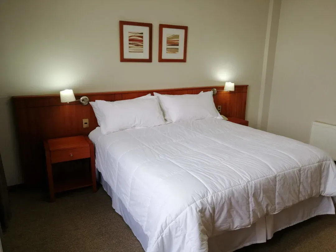 Habitación single con cama, escritorio y aire acondicionado junto a la ventana