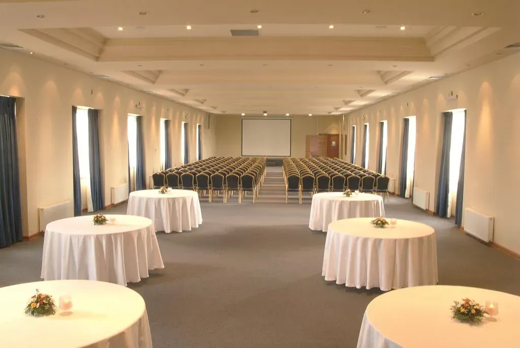 Salón Quinto Piso en montaje auditorio con pantalla y mesas de trabajo