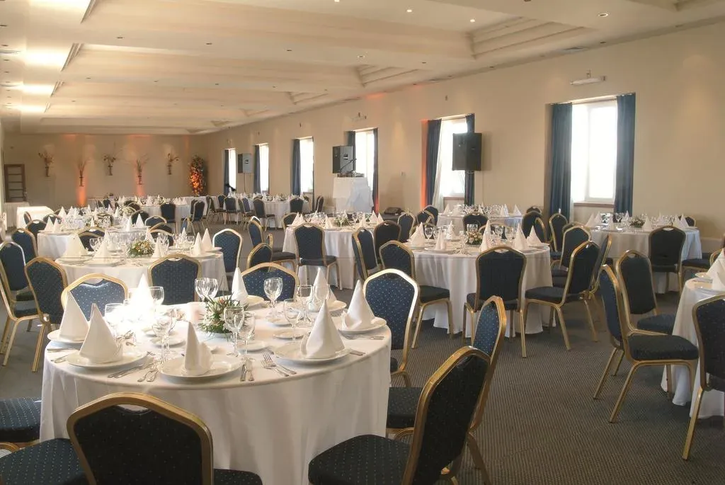 Salón del quinto piso montado con mesas redondas de mantel blanco para una cena