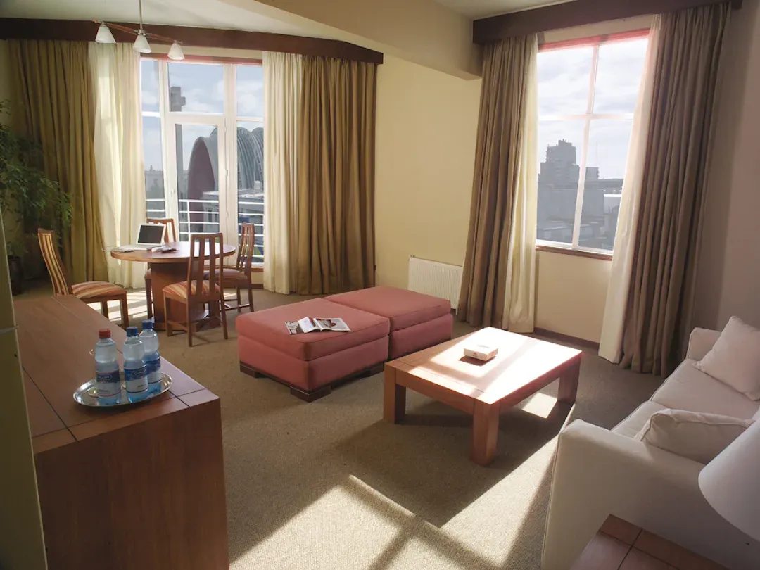 Living de la suite con sofá, mesa de centro y vista a la catedral de Chillán