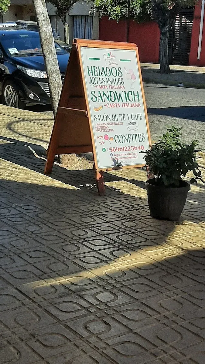 Cartel de vereda de Il Gourmet anunciando helados artesanales con un cono pintado