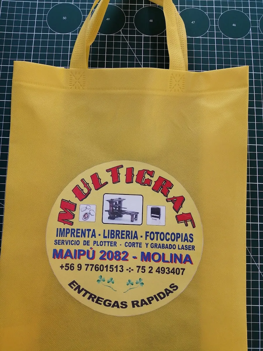 Bolsa amarilla de marca con el logo circular de MULTIGRAF: imprenta, librería, fotocopias y entregas rápidas