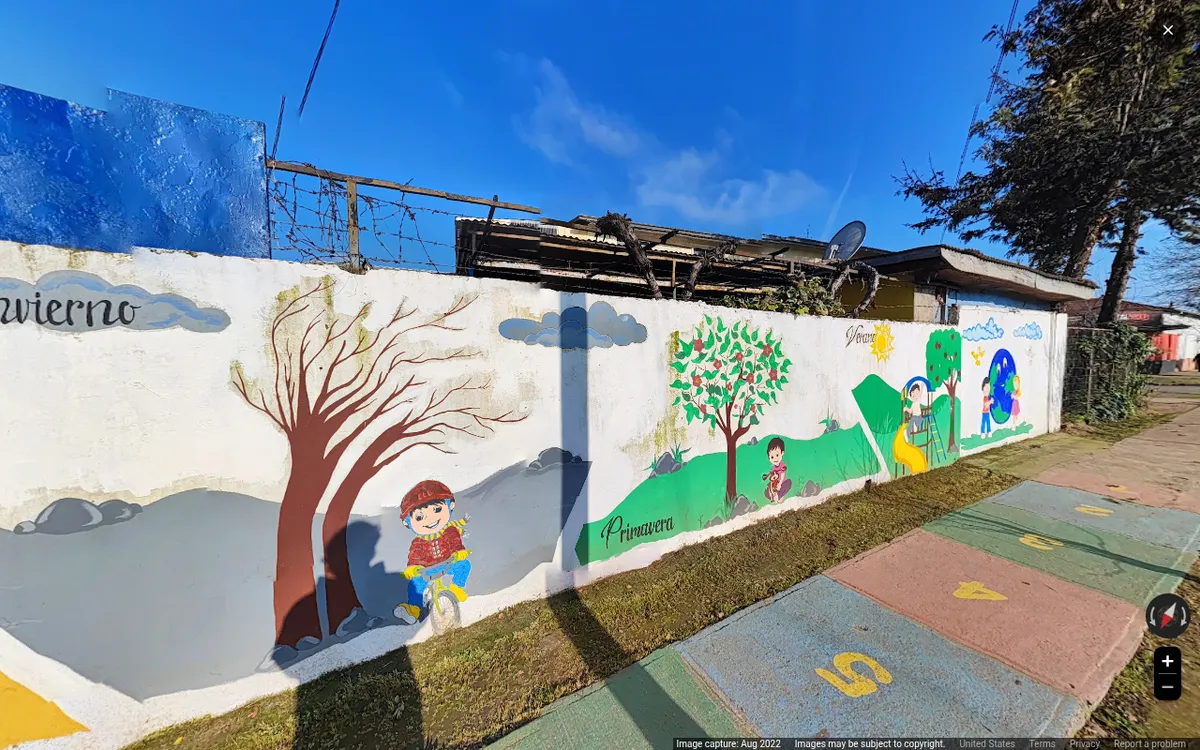 Mural del jardín ABC con las estaciones del año pintadas, un niño en bicicleta y la vereda con rayuela de colores