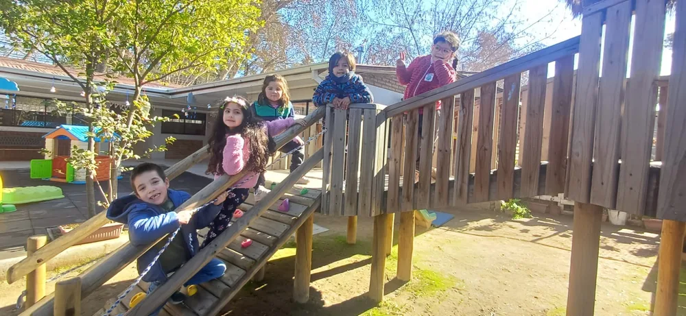 Niños jugando en la estructura de madera del patio del jardín