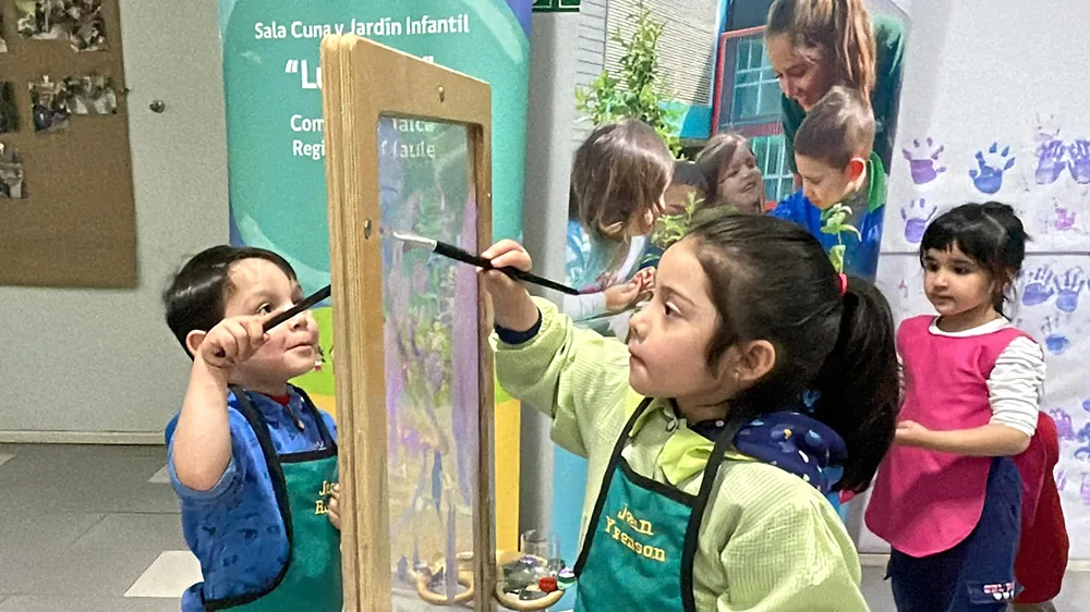 Niños y niñas pintando en un caballete dentro del Jardín Lucerito