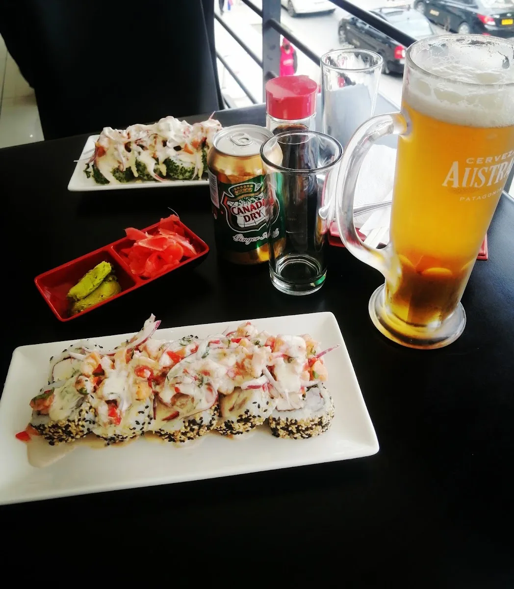 Mesa con rolls, cerveza y bebidas en Kai Sushi