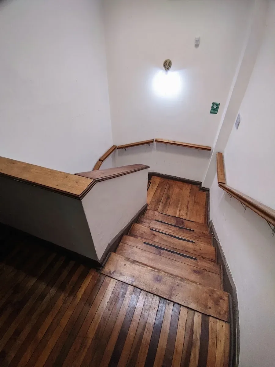 Escalera de madera que sube a la consulta en el segundo piso del cowork