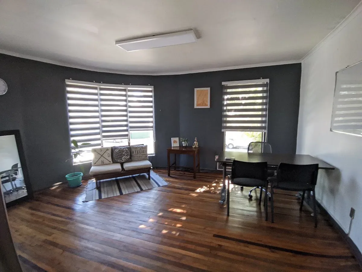 Consulta de Kevin Celedón: escritorio, sillones y luz natural sobre piso de madera