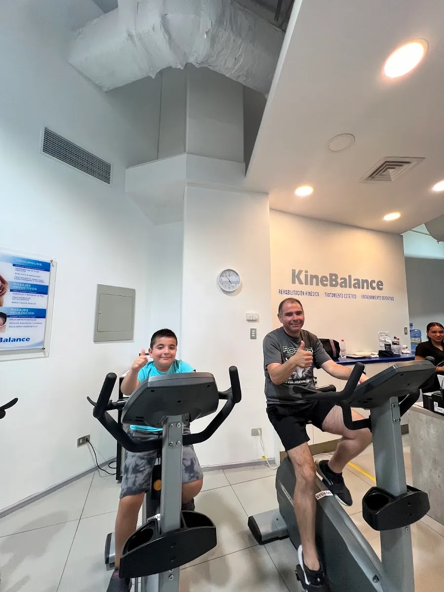 Sala de Kinebalance: pacientes en bicicletas junto al muro con los tres servicios del centro