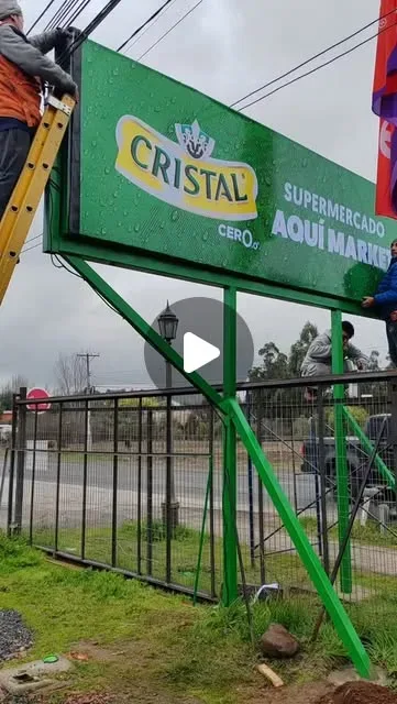 Valla verde del supermercado Cristal instalada en postes verdes