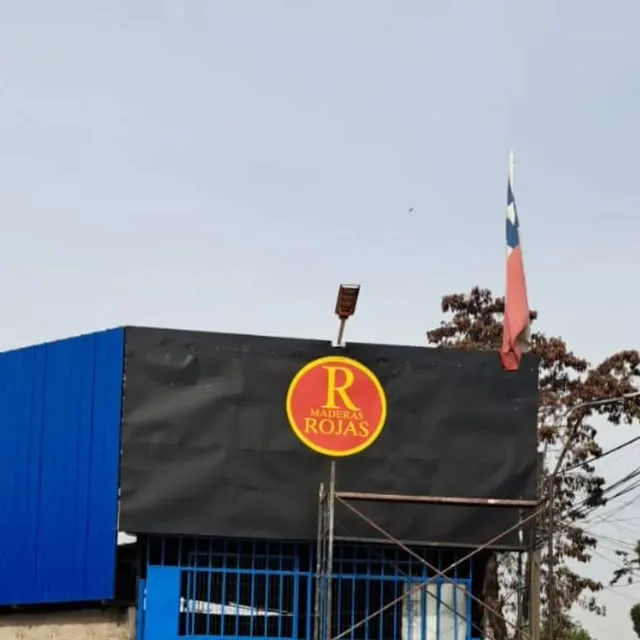 Valla negra con el logo amarillo de R Rojas instalada sobre una bodega