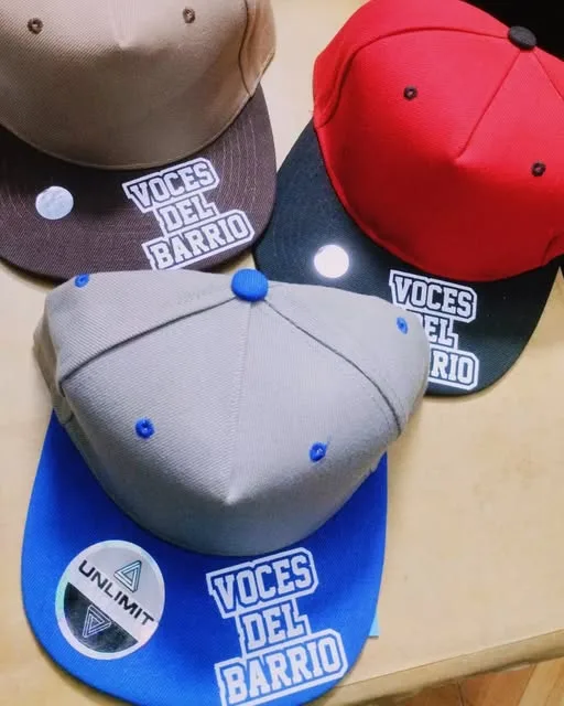 Gorras del sello Voces del Barrio estampadas por KR