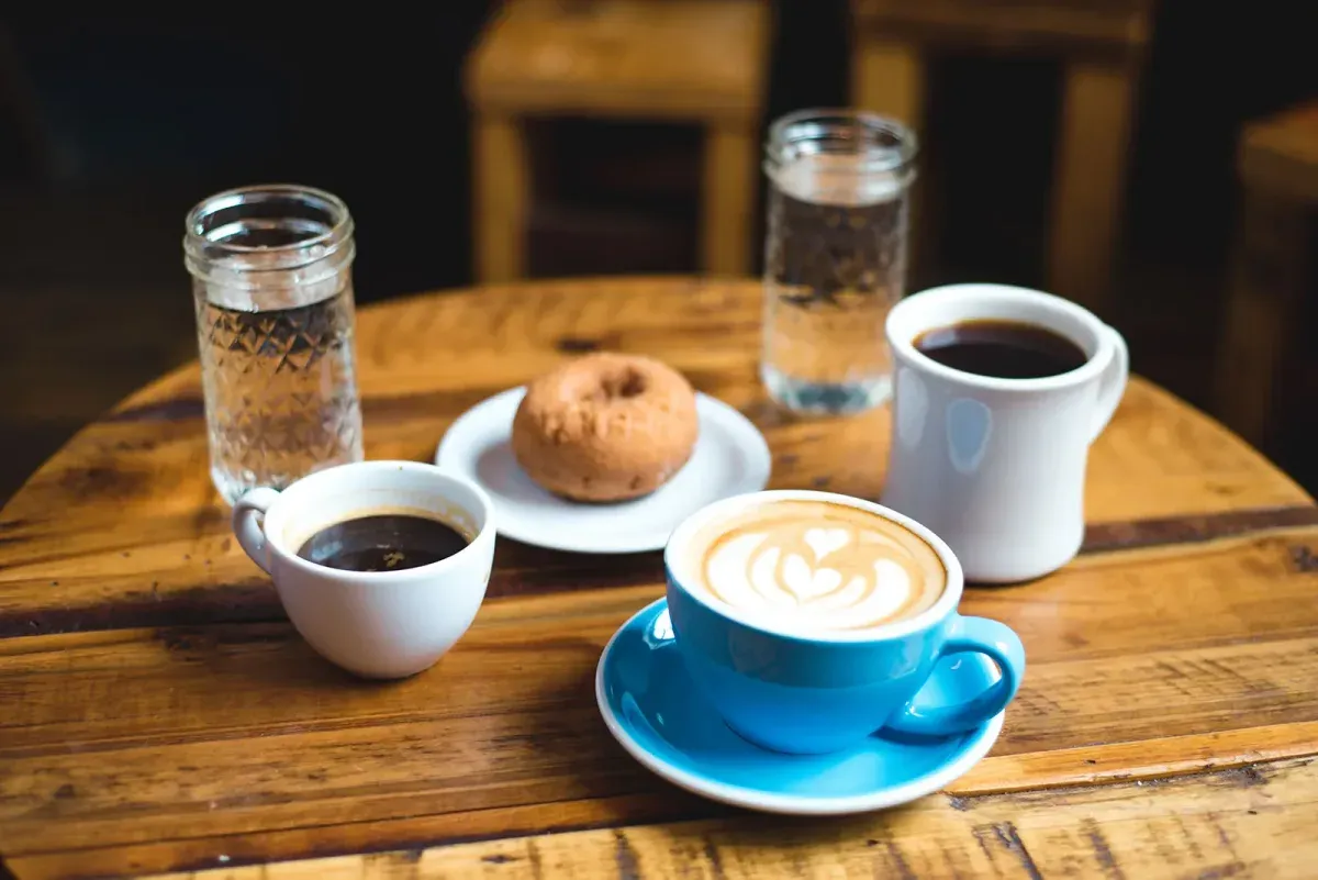 Mesa servida con café y pastelería