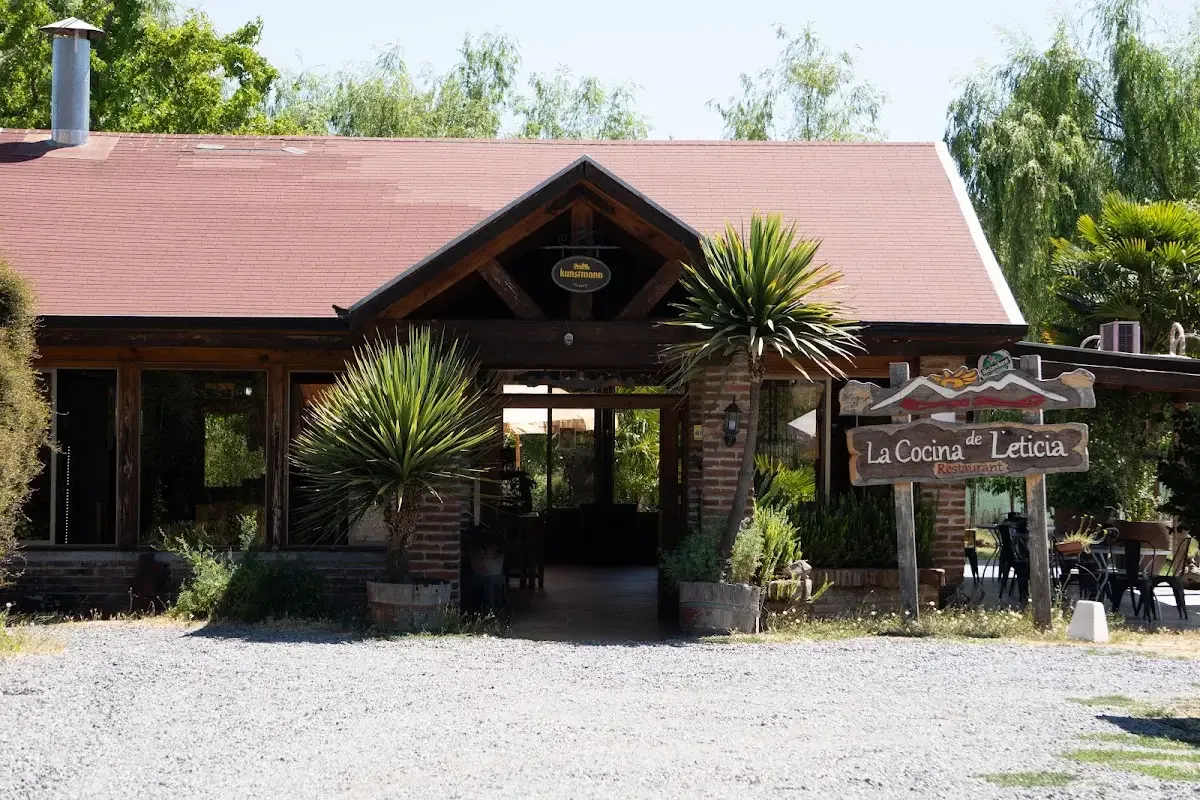 Fachada de La Cocina de Leticia: casa de madera con techo rojo y su letrero camino a Vilches