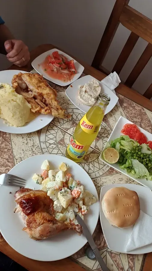 Mesa de almuerzo casero en La Gaviota: pollo asado, puré, ensalada, pebre y bebida