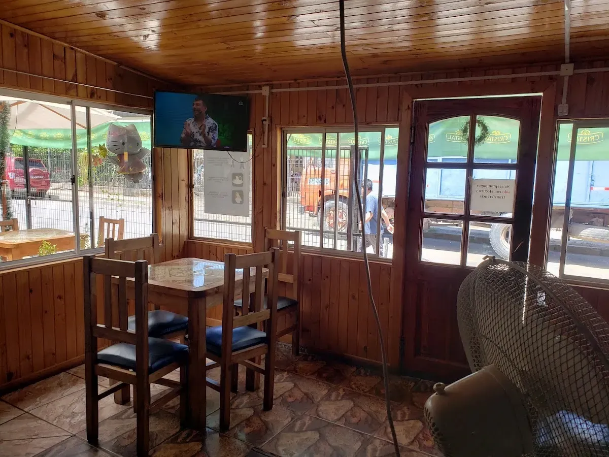 Interior de madera de La Gaviota con mesas y posters de cerveza
