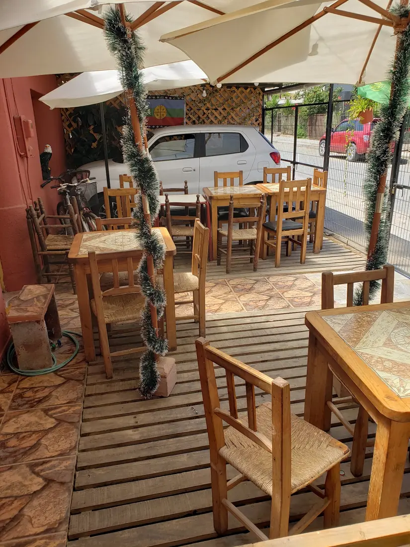 Terraza de madera con sombrillas y mesas de La Gaviota en Licantén