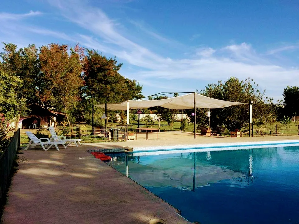 Piscina con toldo de sombra y terraza en La Guatatrucha, centro de eventos en Molina