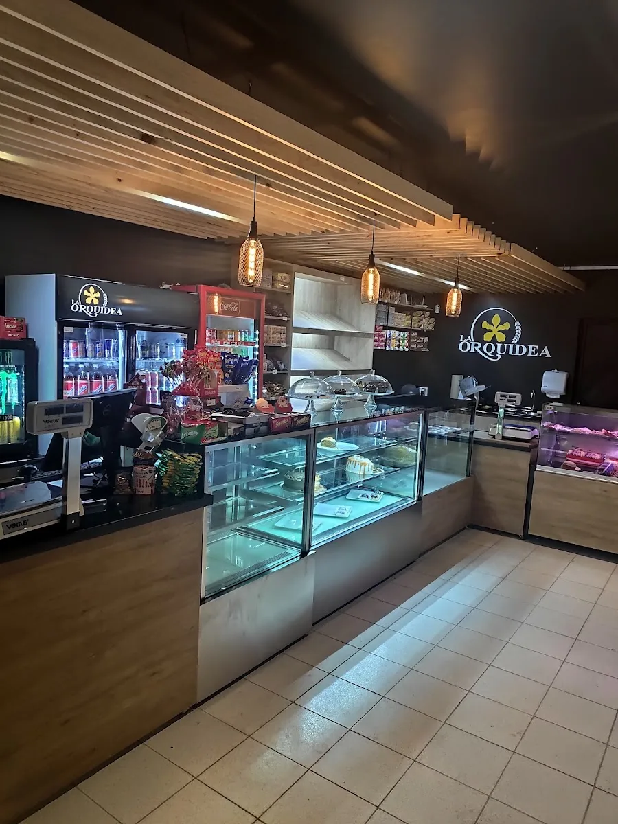 Interior de La Orquídea: vitrinas refrigeradas y el logo en la muralla