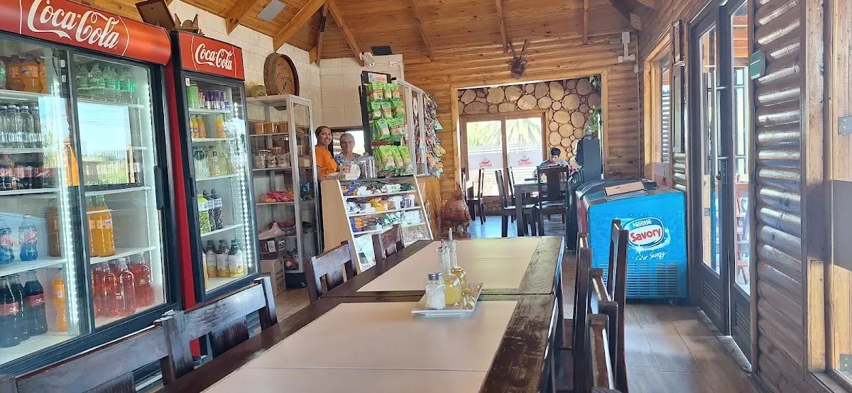 Interior de La Sureña: muros y vigas de madera estilo cabaña sureña