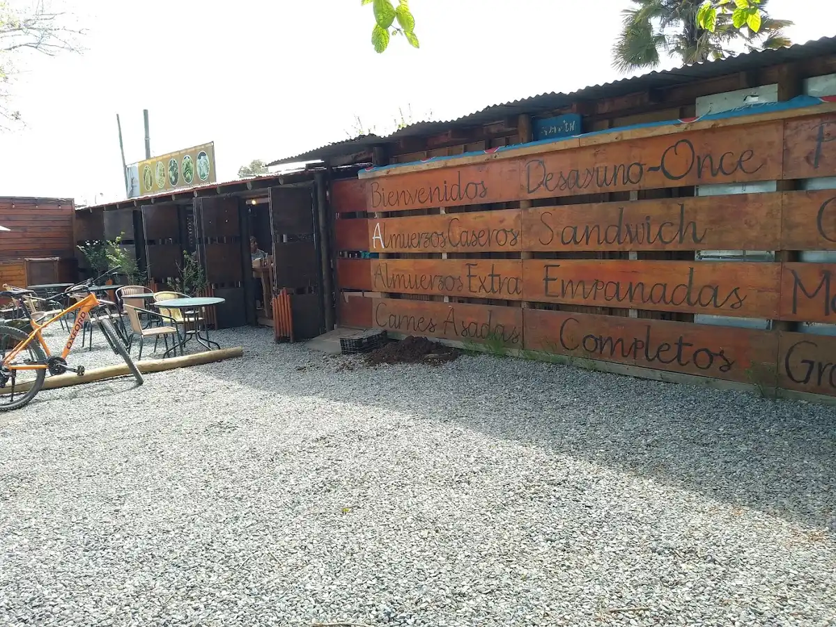 Terraza con mesas junto al muro de pallets y el menú manuscrito de La Tribu Silva