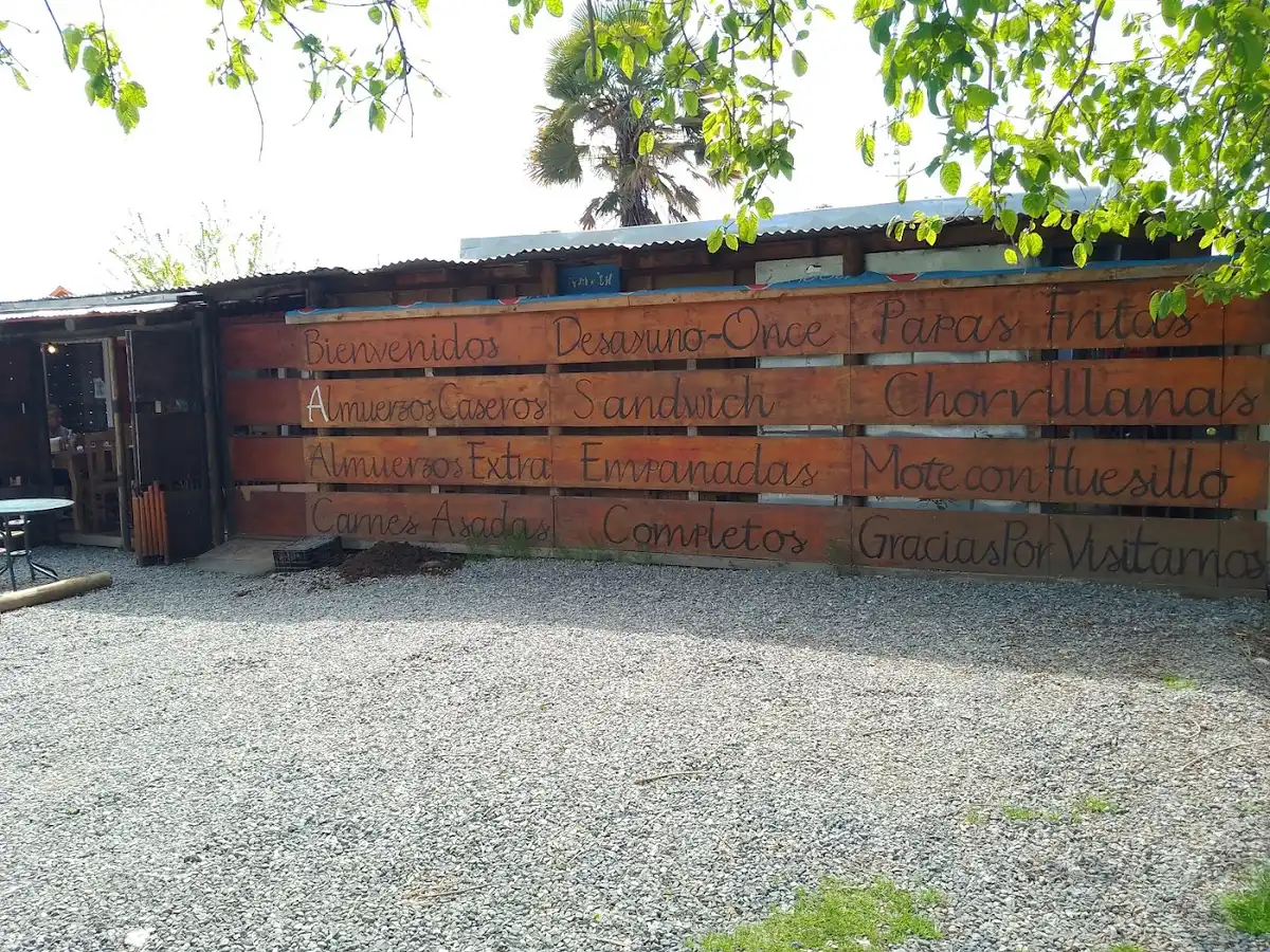 Muro de pallets con el menú manuscrito de La Tribu Silva: desayuno, once, almuerzos, empanadas y más