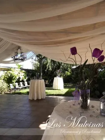 Mesa de cóctel con mantel crema y orquídea en la terraza de Las Malvinas