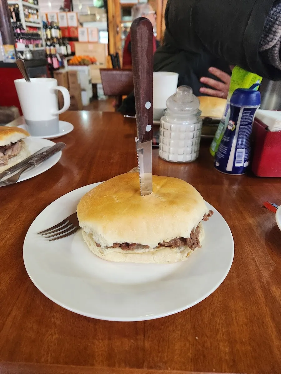 Sándwich de churrasco con el cuchillo clavado, estilo de la casa