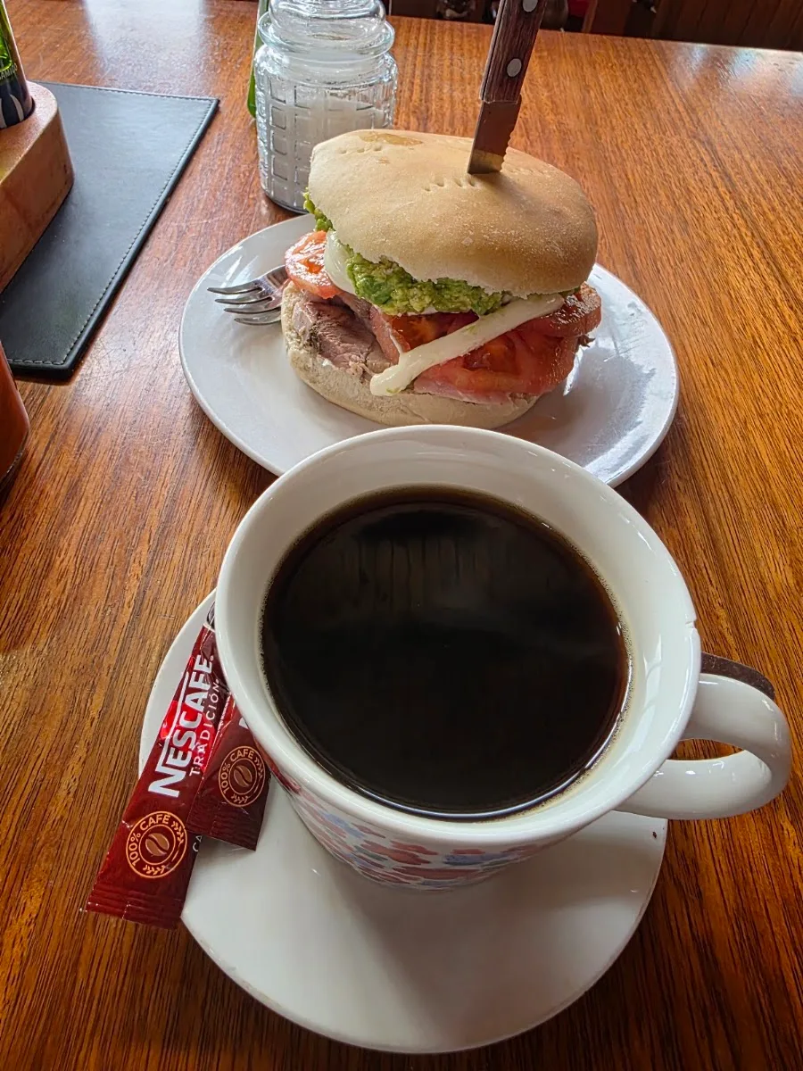 Desayuno con sándwich y café servido en la mesa