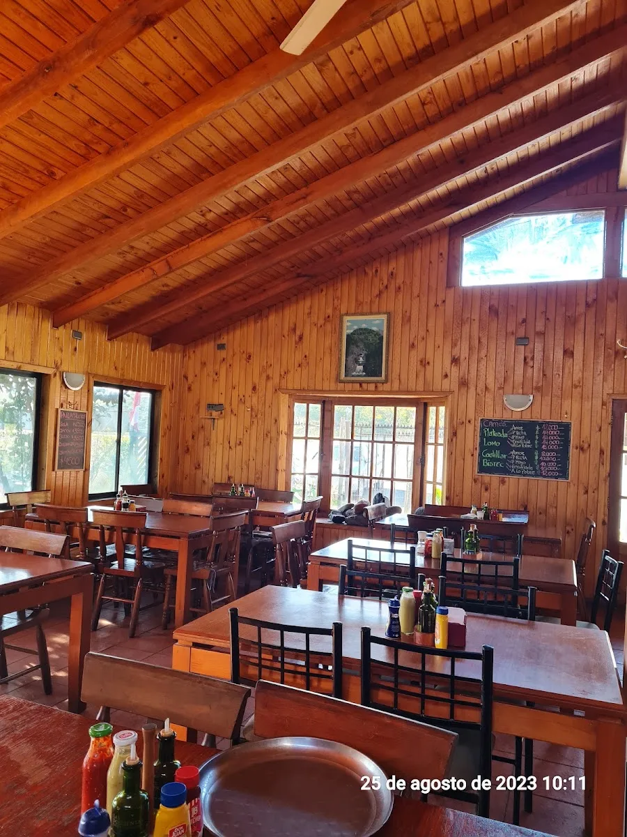 Comedor interior de madera con la pizarra del menú escrita a mano