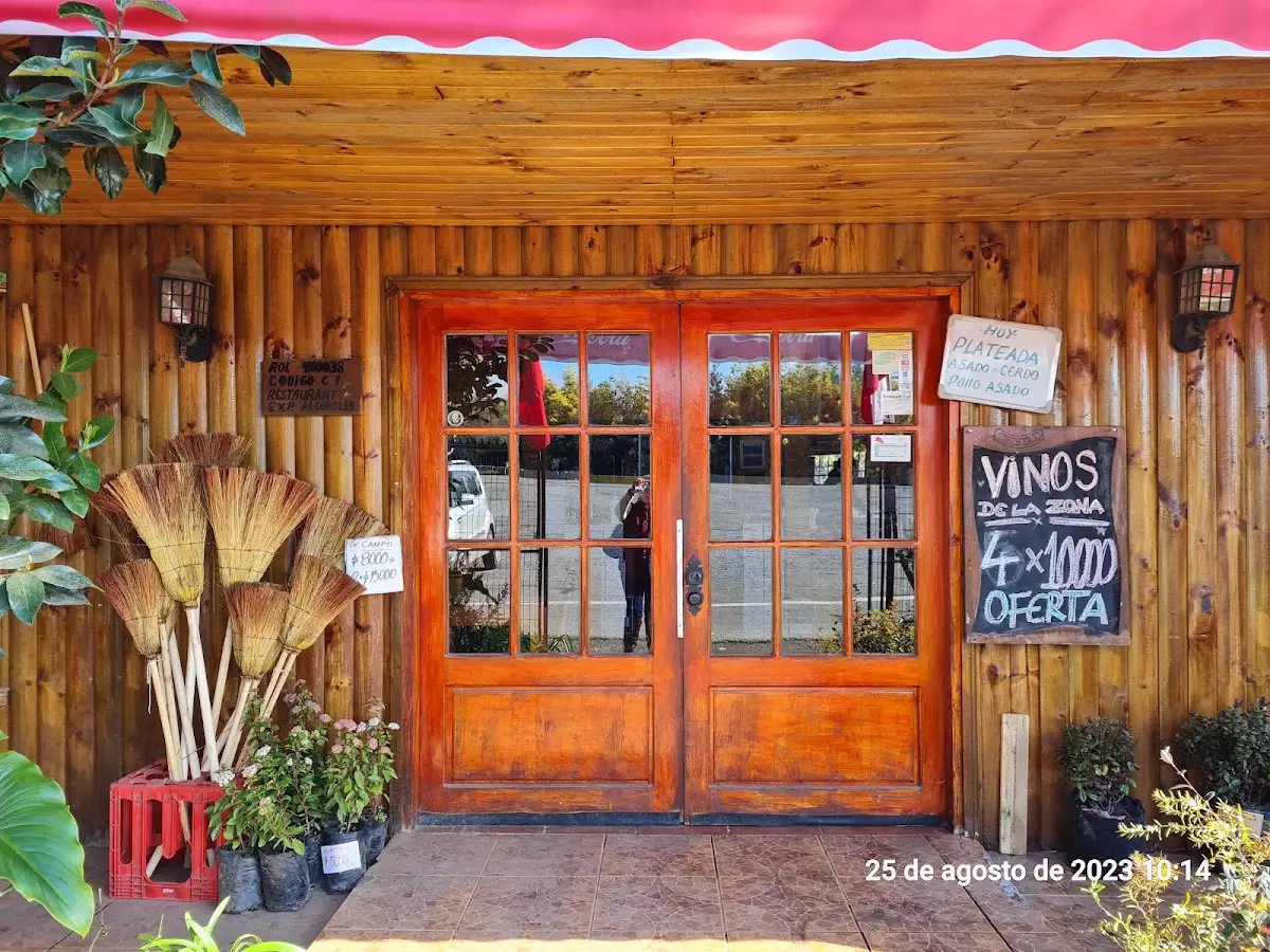 Los portones de madera de la entrada de Las Puertas del Paraíso, con la pizarra de platos del día y la oferta de vinos