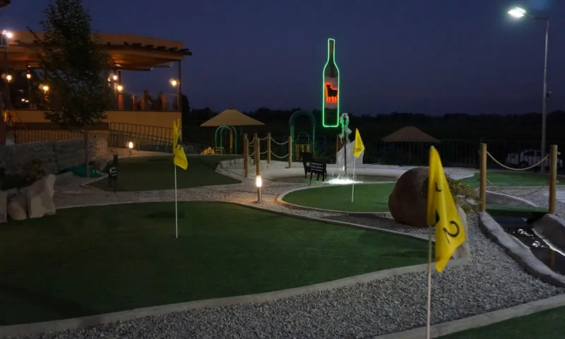 Mini golf de Los Ganaderos de noche, con el neón de la botella encendido