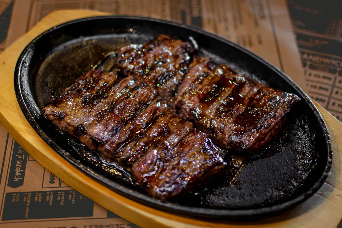 Corte de carne a la parrilla servido en sartén de fierro