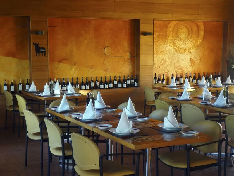 Salón y vinoteca interior con barricas y vinos de la zona