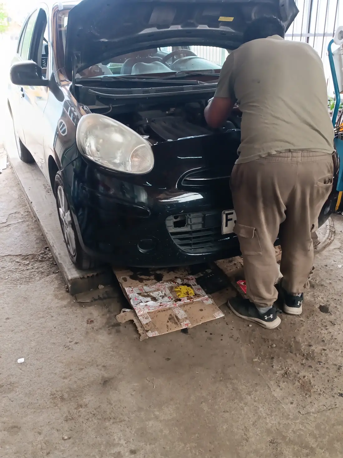 Persona del equipo de Lubricantes Sepúlveda trabajando en el motor de un auto en el taller