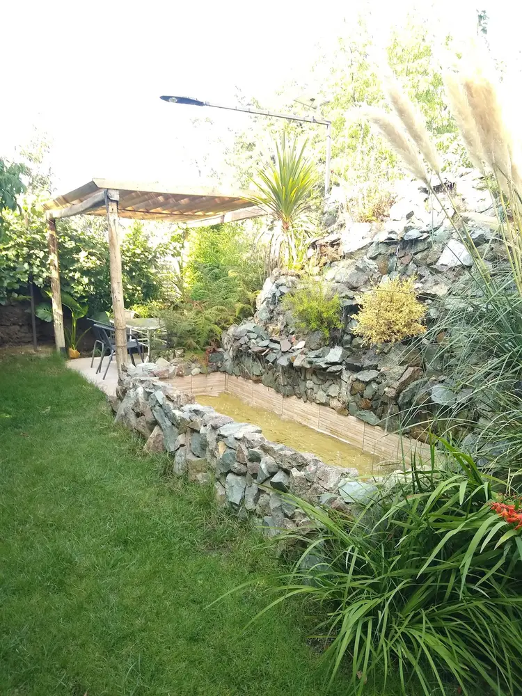 Jardín con rocalla y estanque en Luna Plena Hostal