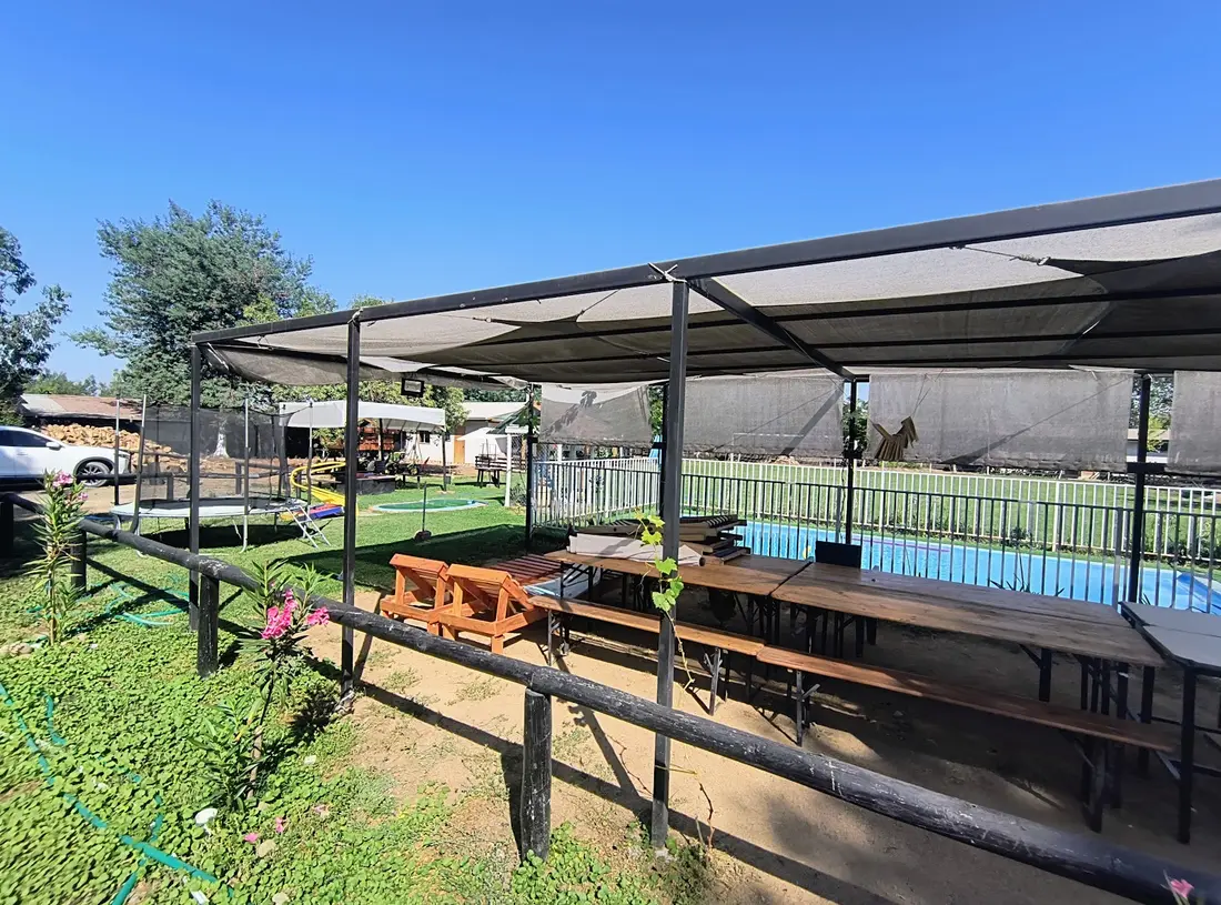 Quincho con mesones junto a la piscina del hostal