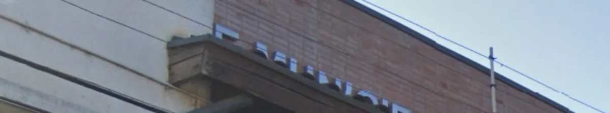 Detalle del letrero con letras metálicas sobre la fachada de ladrillo