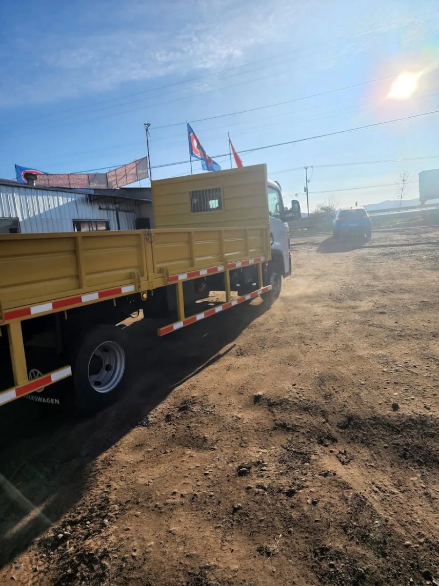 Camión con caja amarilla fabricada saliendo del taller por la Ruta 5