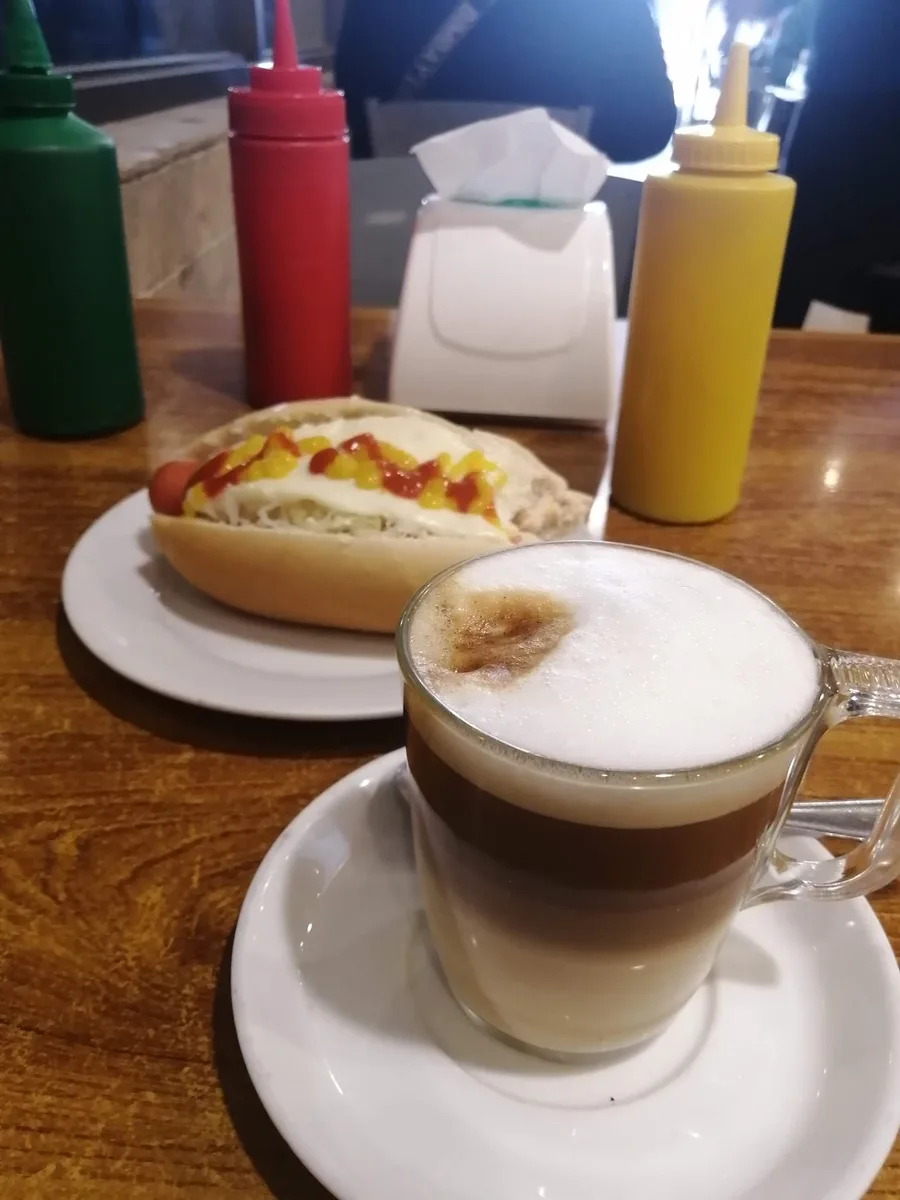 Completo y cappuccino sobre la mesa de madera del café