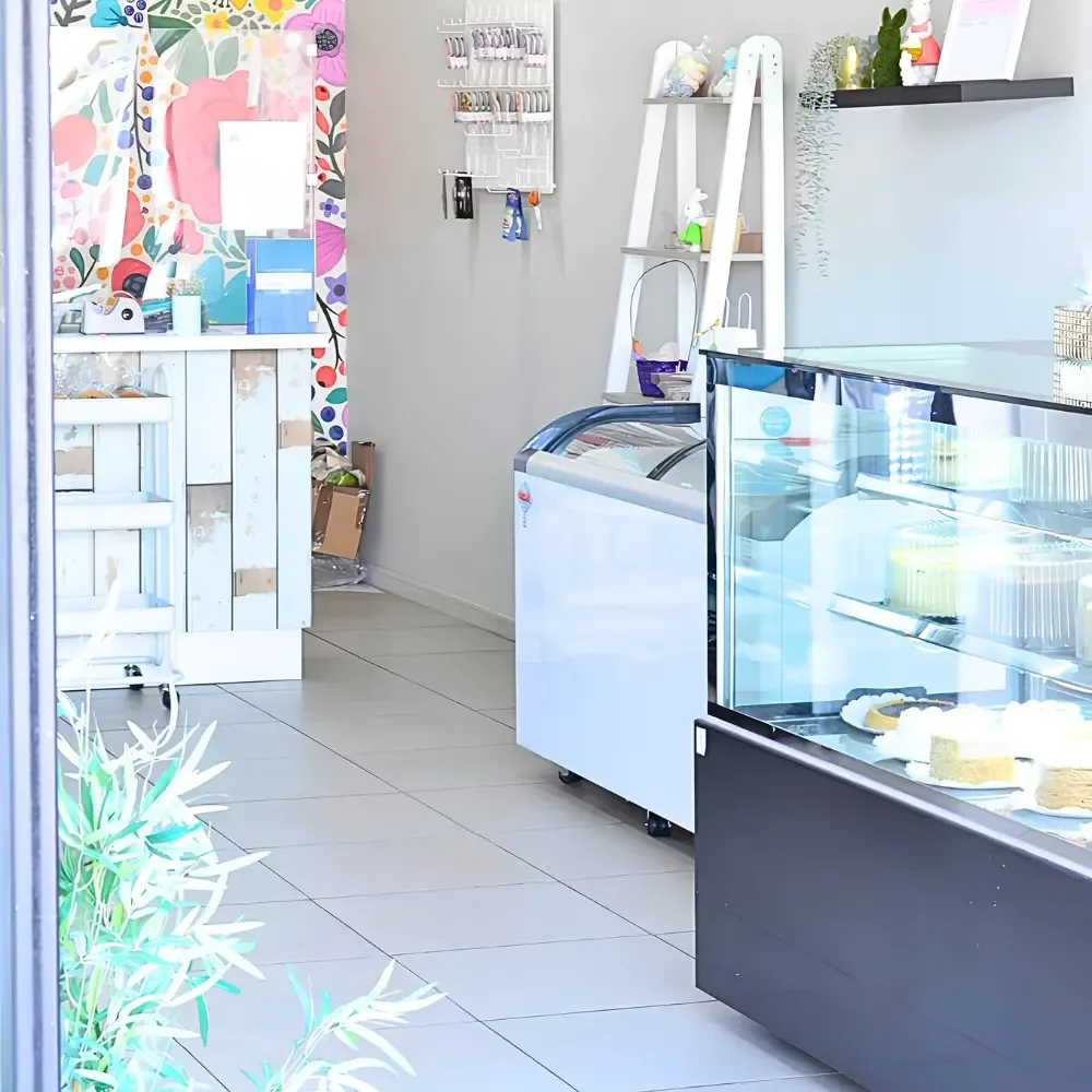 Interior del local de la pastelería con mural pintado y vitrinas