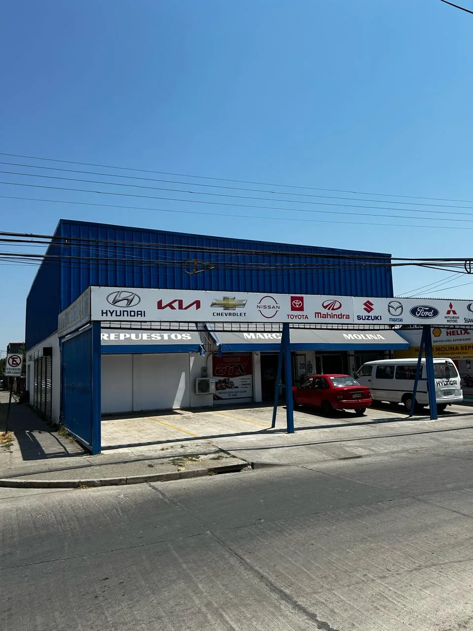 Fachada de Marco Molina Repuestos: local azul con marquesina de marcas en Av. Brasil 201