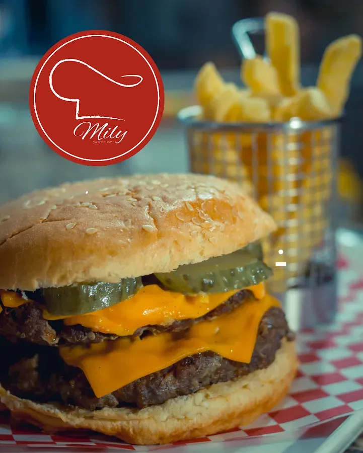 Hamburguesa doble con queso y pepinillos, papas fritas en canastita y el pick rojo de Mily