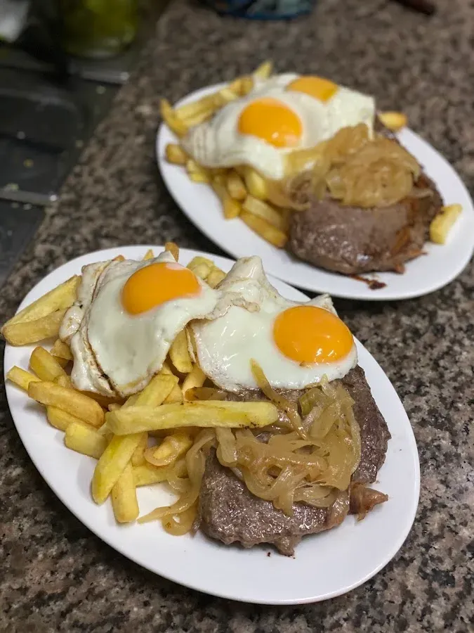 Plato de fondo con bistec, huevos fritos y papas fritas
